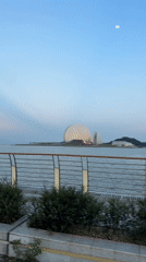 Cyclist tours Xiangzhou waterfront past distinctive dome architecture
