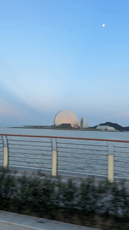 Cyclist tours Xiangzhou waterfront past distinctive dome architecture