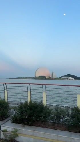 Cyclist tours Xiangzhou waterfront past distinctive dome architecture