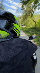 Two-person scooter ride observed on tree-lined road in Gabrovo