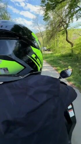Two-person scooter ride observed on tree-lined road in Gabrovo