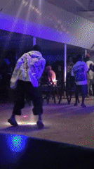 Evening social gathering at neon-lit bar in Wumat, Nigeria