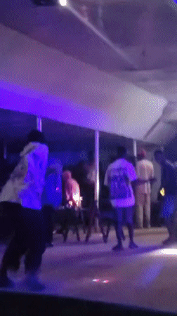 Evening social gathering at neon-lit bar in Wumat, Nigeria