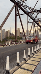 Fire truck crosses a red truss bridge in NYC