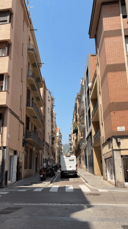 Quiet Barcelona side street with colorful apartment buildings and balcony plants
