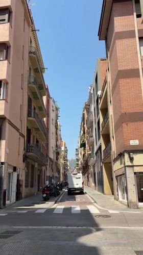 Quiet Barcelona side street with colorful apartment buildings and balcony plants