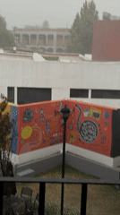 Woman documents rainy evening from balcony in Cholula