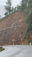 Wet road conditions observed near eroded hillside in Tân Uyên