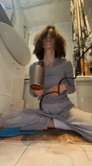Woman dries hair on bathroom floor in Moscow