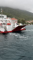 Ferry carries vehicles between Montenegro towns on cloudy morning