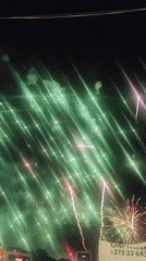 Colorful fireworks display with stage structure visible at night