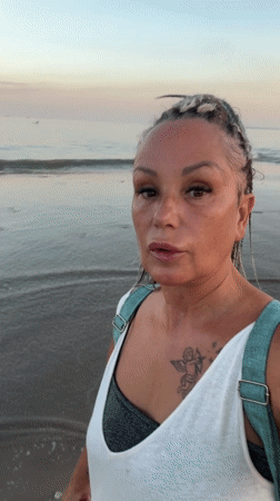 Woman walks barefoot on Indonesian beach at sunrise