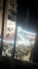 Nighttime community gathering illuminated by festive lights in Khan Yunis