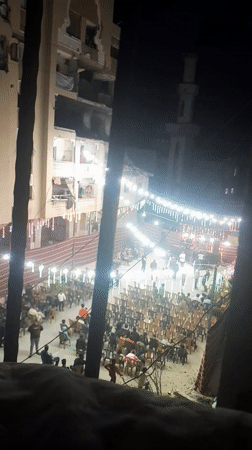 Nighttime community gathering illuminated by festive lights in Khan Yunis