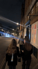 Group of young adults walk London street at night