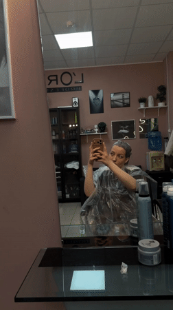 Woman takes selfie during hair treatment at Russian salon