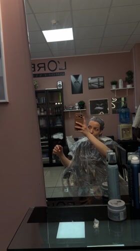 Woman takes selfie during hair treatment at Russian salon