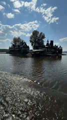 Boat on the water and a medieval stone tower in Satka