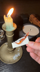 Person burns card with text over candle in Cape Town