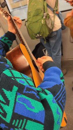 Street musician performs guitar on moving Berlin train