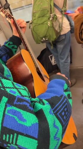 Street musician performs guitar on moving Berlin train