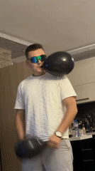 Man juggles balloons, relaxes with cat in apartment