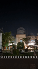 Illuminated mosque captured under crescent moon in Lhokseumawe