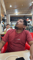 Man vapes while using phone in Lhokseumawe cafe