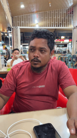 Man vapes while using phone in Lhokseumawe cafe