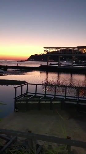Sochi waterfront at golden hour: beach, volleyball, and lit-up coastline