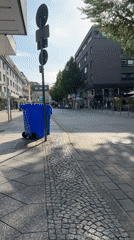 Krefeld pedestrian street, lampshades overhead, cafes open for the day