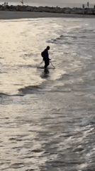 Metal detector enthusiast searches Tel Aviv beach waters