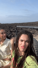 Couple rides open vehicle through volcanic terrain near Tinajo
