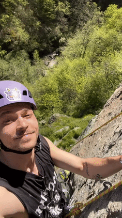 Rock climber with cow-stickered helmet scales grey cliffs in Bulgaria