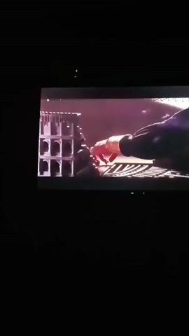 A video shows a hand reaching towards a keyboard. A person is playing a keyboard, and the screen displays a video game. The video game shows two small figures standing on a keyboard.