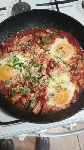 Shakshuka with eggs and meat cooking in Zaporizhzhia