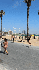 Acrobat performs, mounted police patrol Barcelona's Barceloneta Beach promenade
