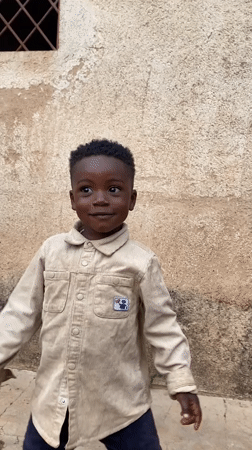 Child plays outside building in Vom, Nigeria