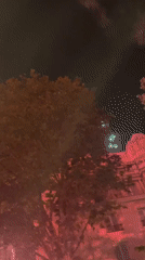 Red fireworks light up Paris sky near Eiffel Tower