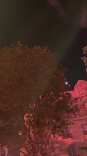 Red fireworks light up Paris sky near Eiffel Tower