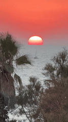 Tel Aviv sunset through smudged glass, Mediterranean horizon glowing red