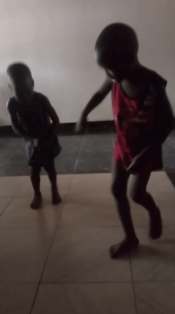 Children dancing, woman resting at home in Goni Gara
