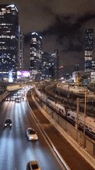 Tel Aviv nighttime cityscape shows active traffic, rail transit