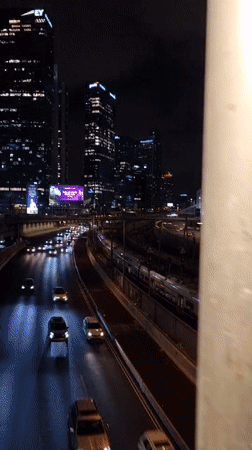 Tel Aviv nighttime cityscape shows active traffic, rail transit