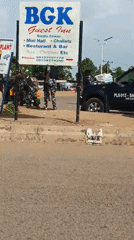Police presence and street vendors share a busy market road