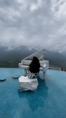 White grand piano at a misty Sa Pa infinity pool