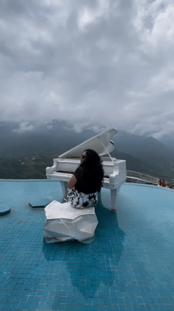 White grand piano at a misty Sa Pa infinity pool