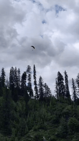 Paragliders, horses, and ATVs on a cloudy Solang Valley morning