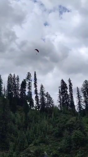 Paragliders, horses, and ATVs on a cloudy Solang Valley morning