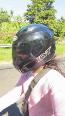 Motorcyclist rides through tropical road in Manggis, Indonesia